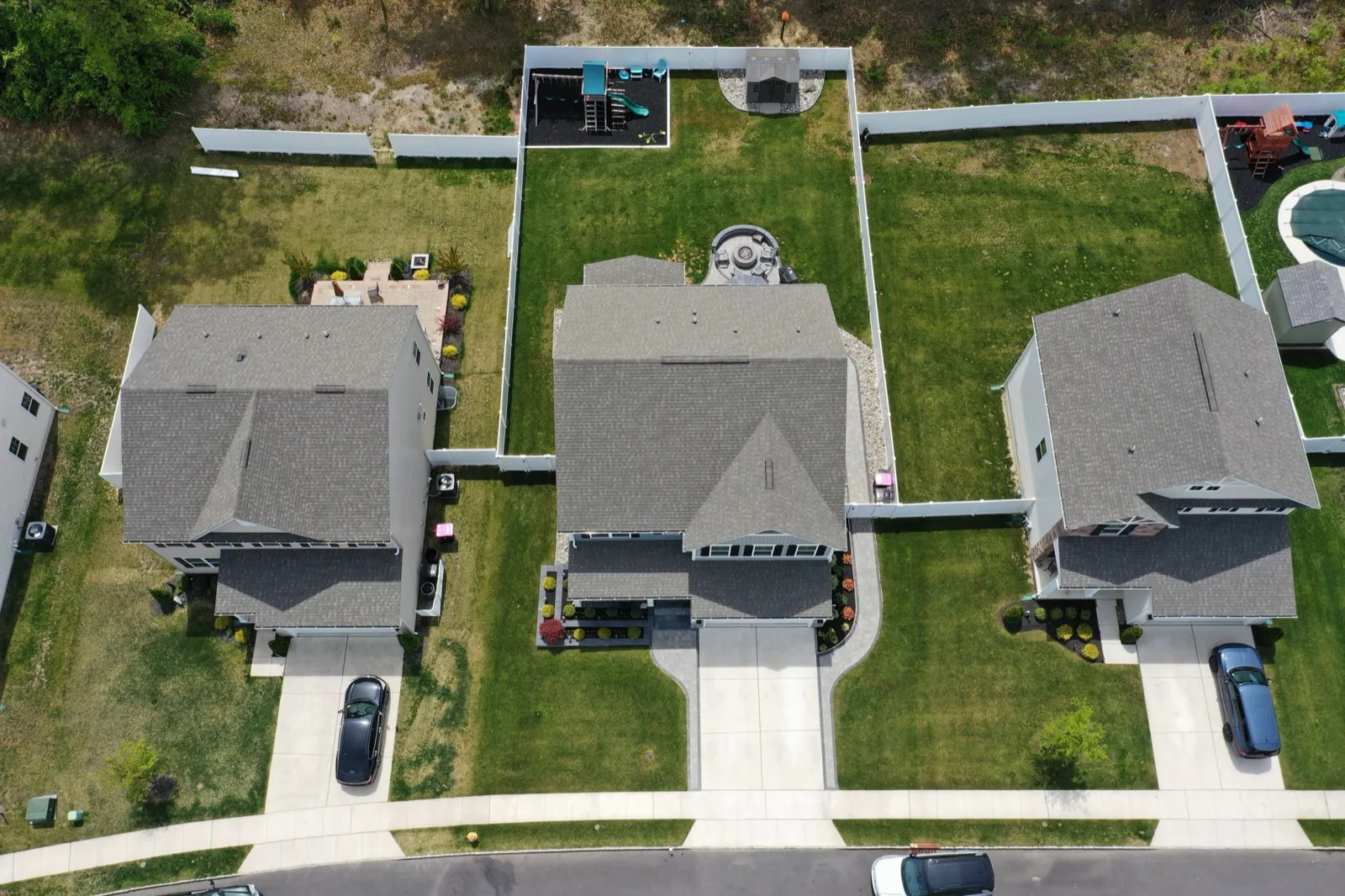 Top-down aerial view of new single-family homes on side-by-side lots along a street