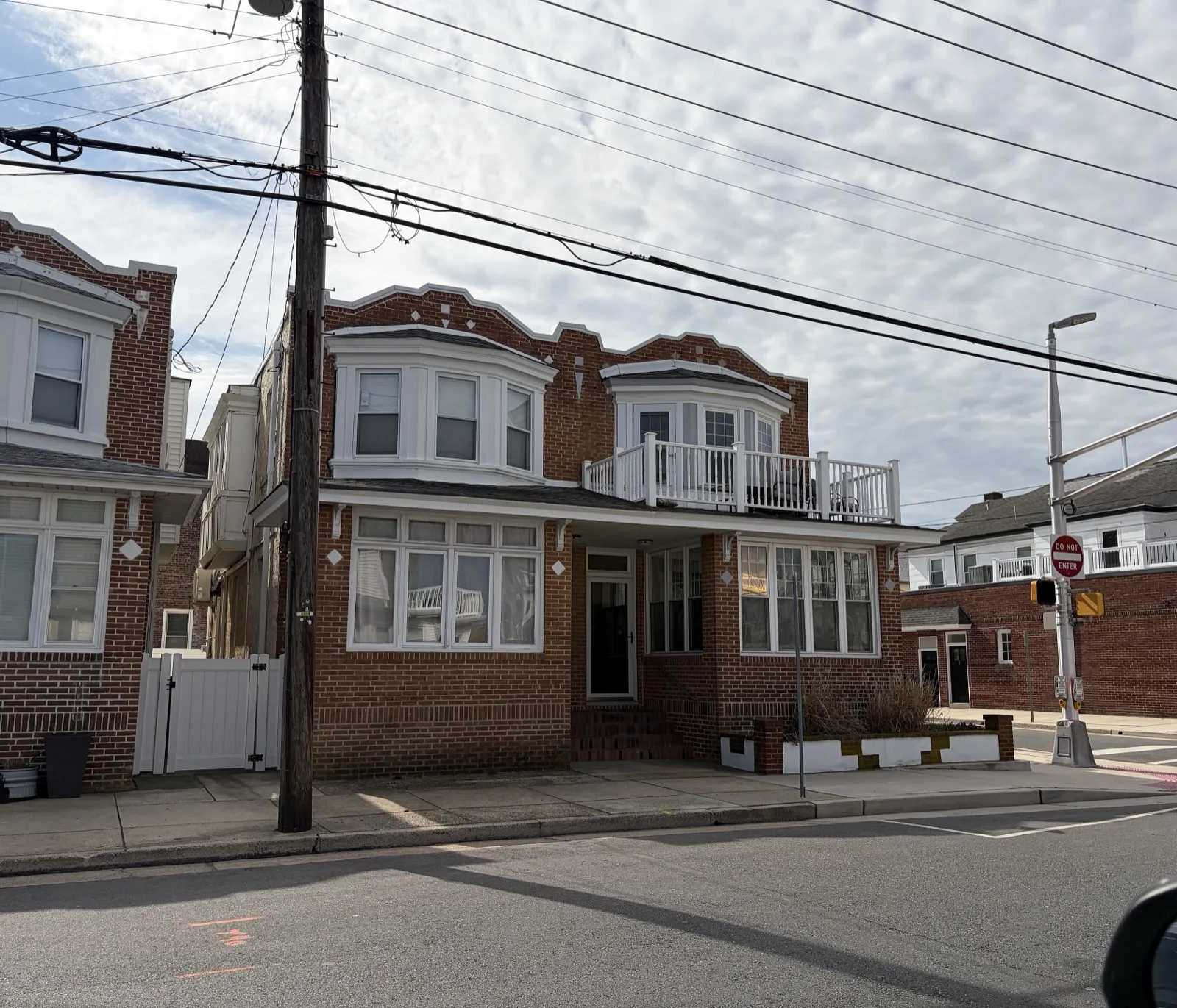 Brick shore rowhouses with bay windows on a corner in Ventnor City