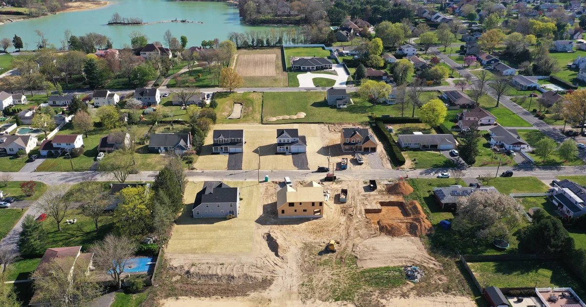 An aerial view of graded home lots and a new street in a Vineland subdivision, with finished houses along the edges